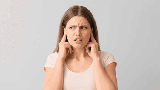 Frustrated person covers ears.